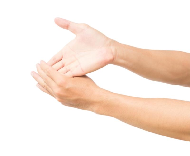 Một người phụ nữ đang thực hiện bài tập kéo giãn cơ bắp chân bằng cách tựa tay vào tường và duỗi chân sau, minh họa một cách chữa đau bắp chân tại nhà.